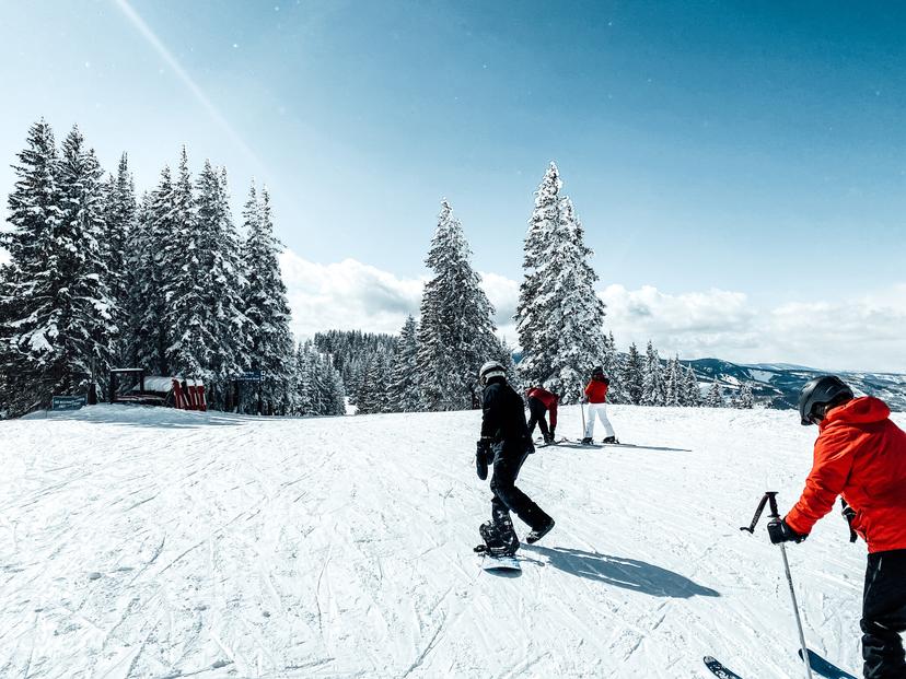 Snowboarders and skiers pushing along